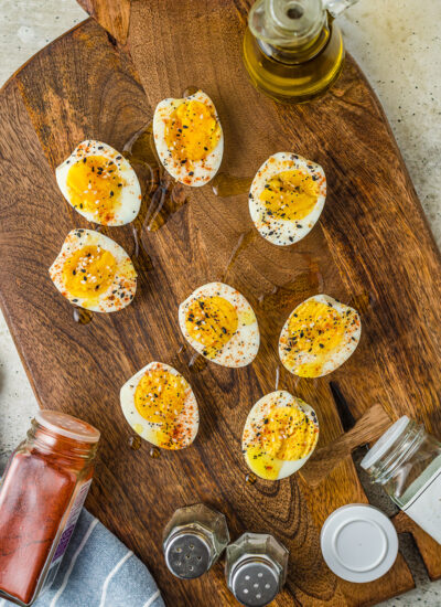 Seasoned hard boiled eggs on a wooden serving tray