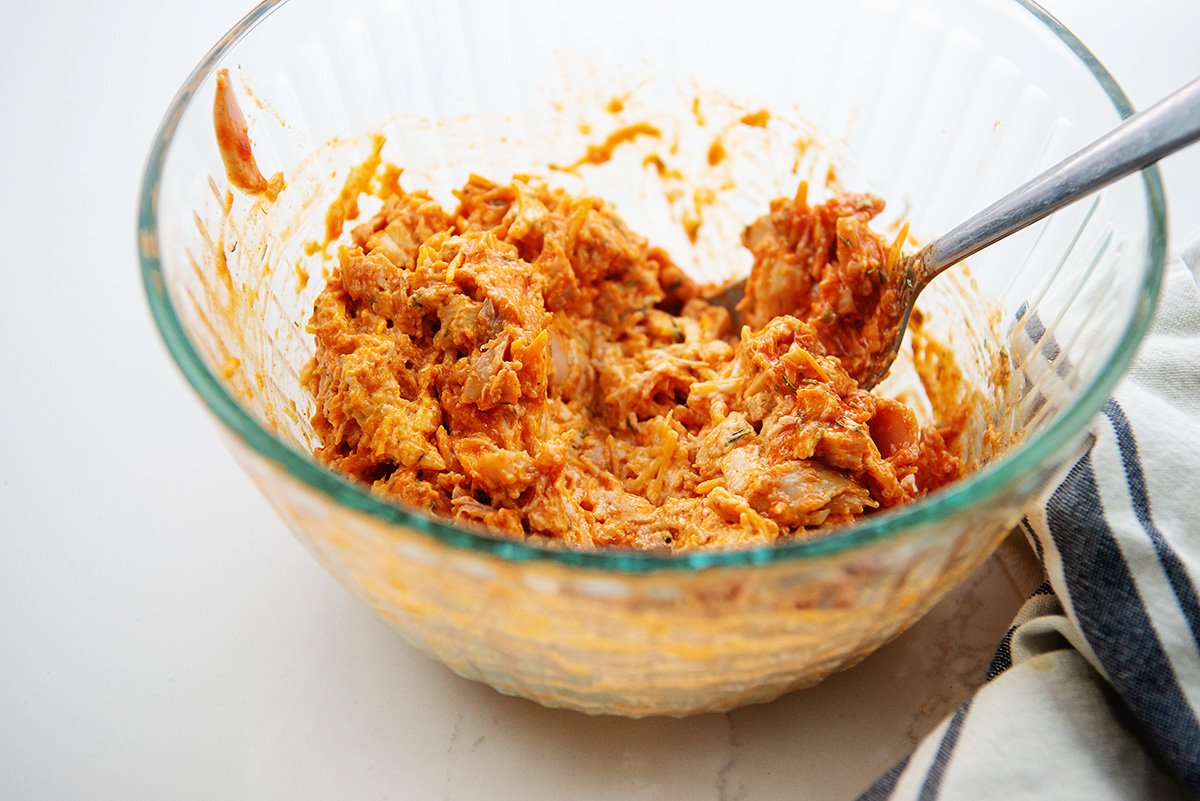 Buffalo chicken filling in a clear glass bowl