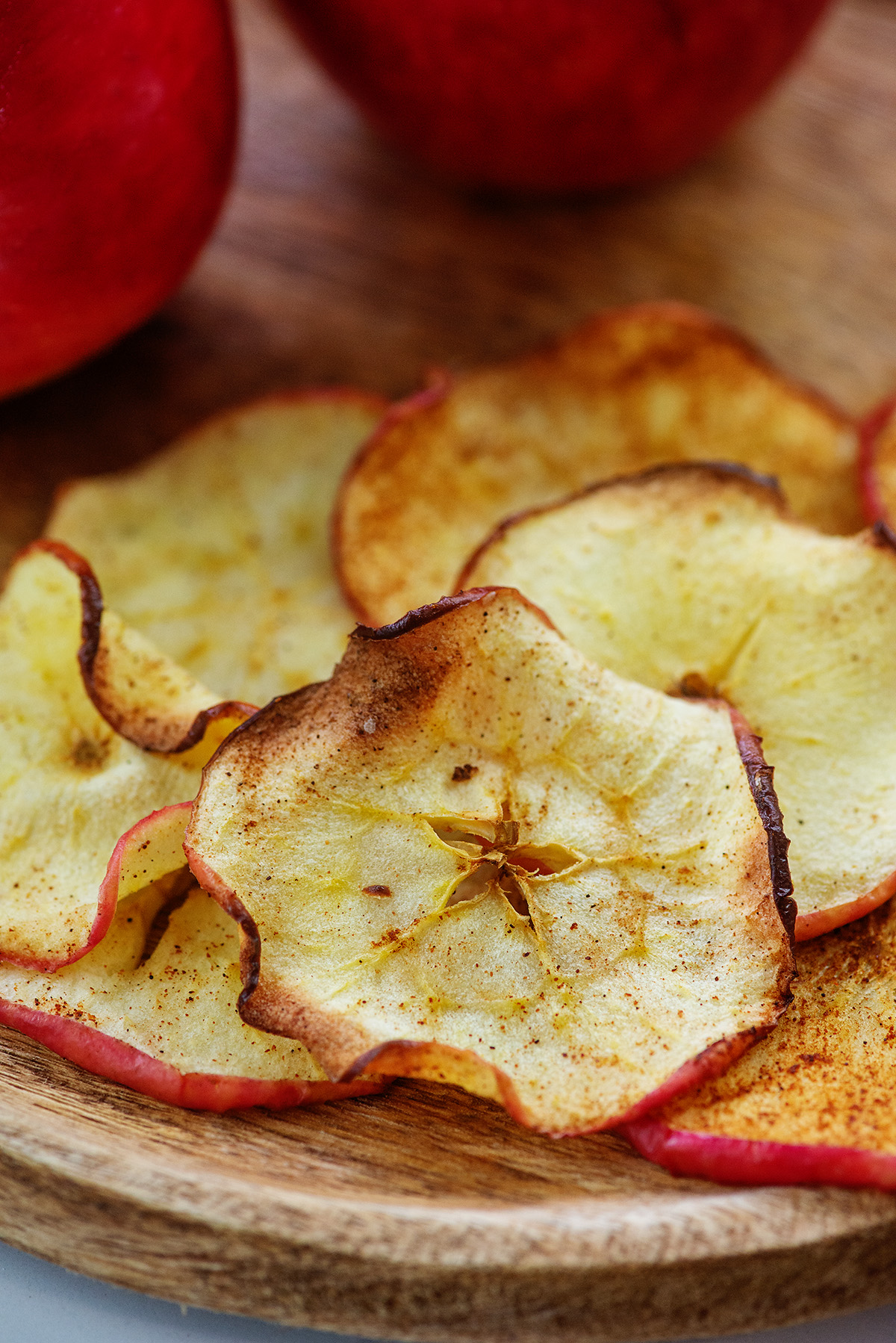 Close up of apple chips on a wooden plate