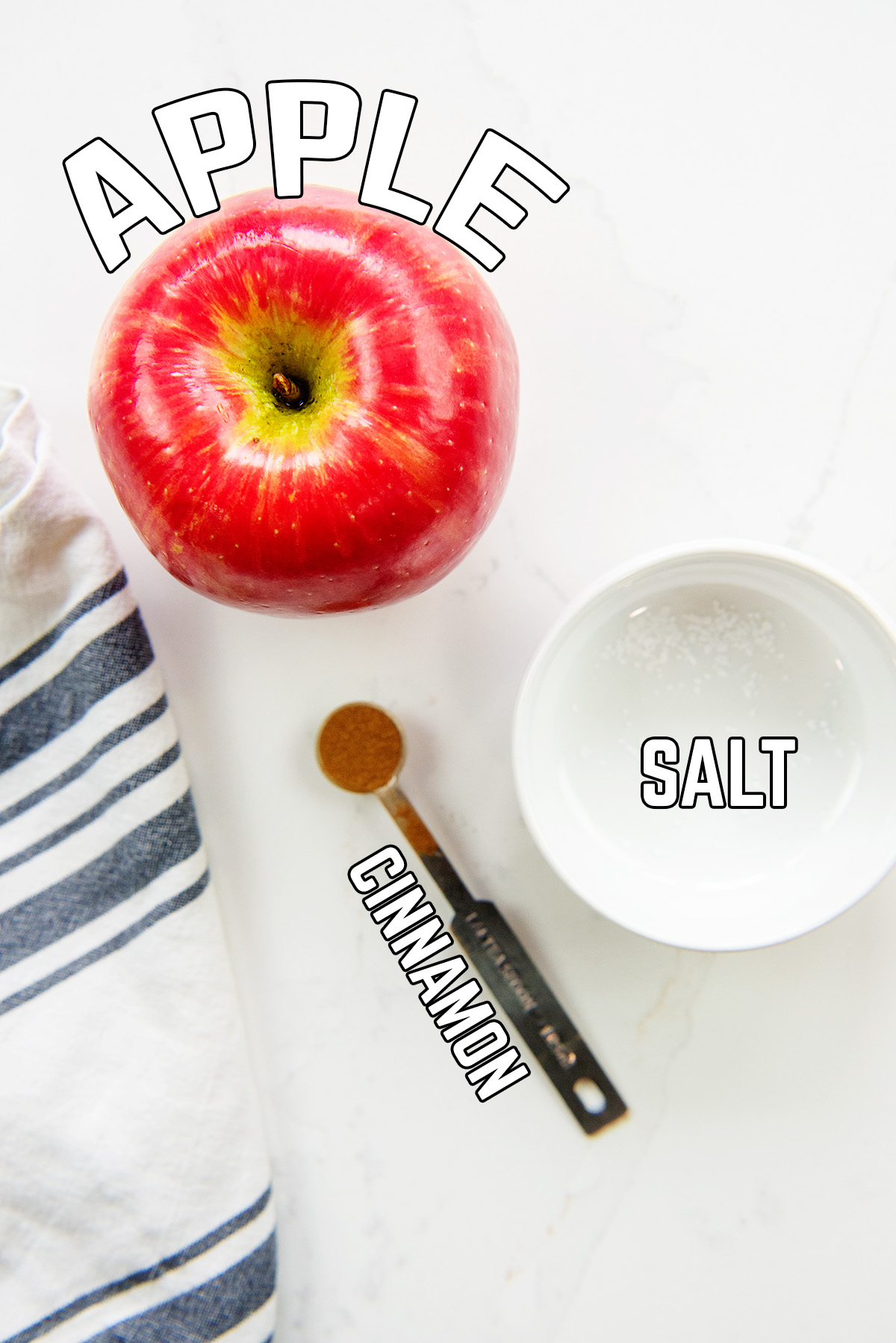 An apple and seasonings spread out on a counter top