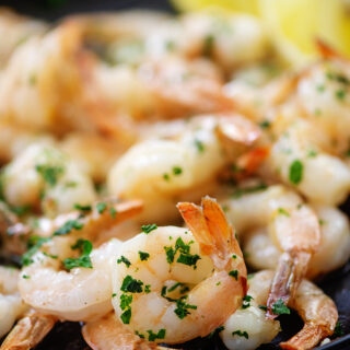cooked shrimp with parsley on plate.