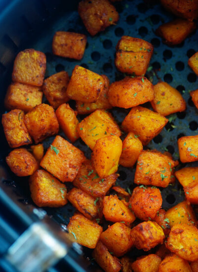 Close up of cooked cubes of butternut squash, seasoned.
