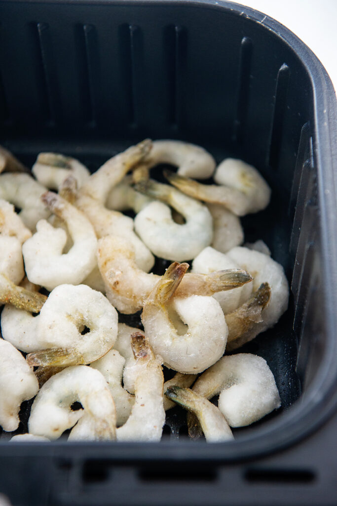 frozen shrimp in air fryer basket.