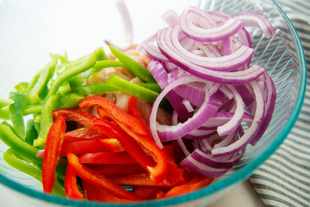 peppers and onions in a clear glass bowl.
