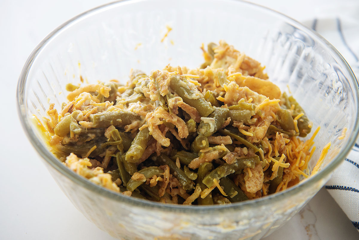 Green beans, fried onions, and cheese in a clear glass bowl