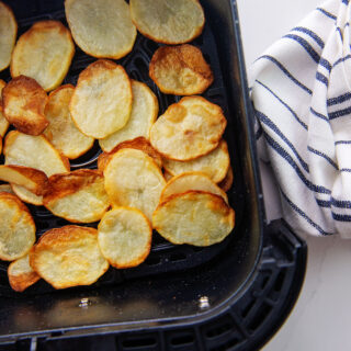 potato chips in an air fryer basket.