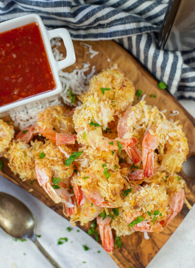 Close up of coconut shrimp on a cutting board.