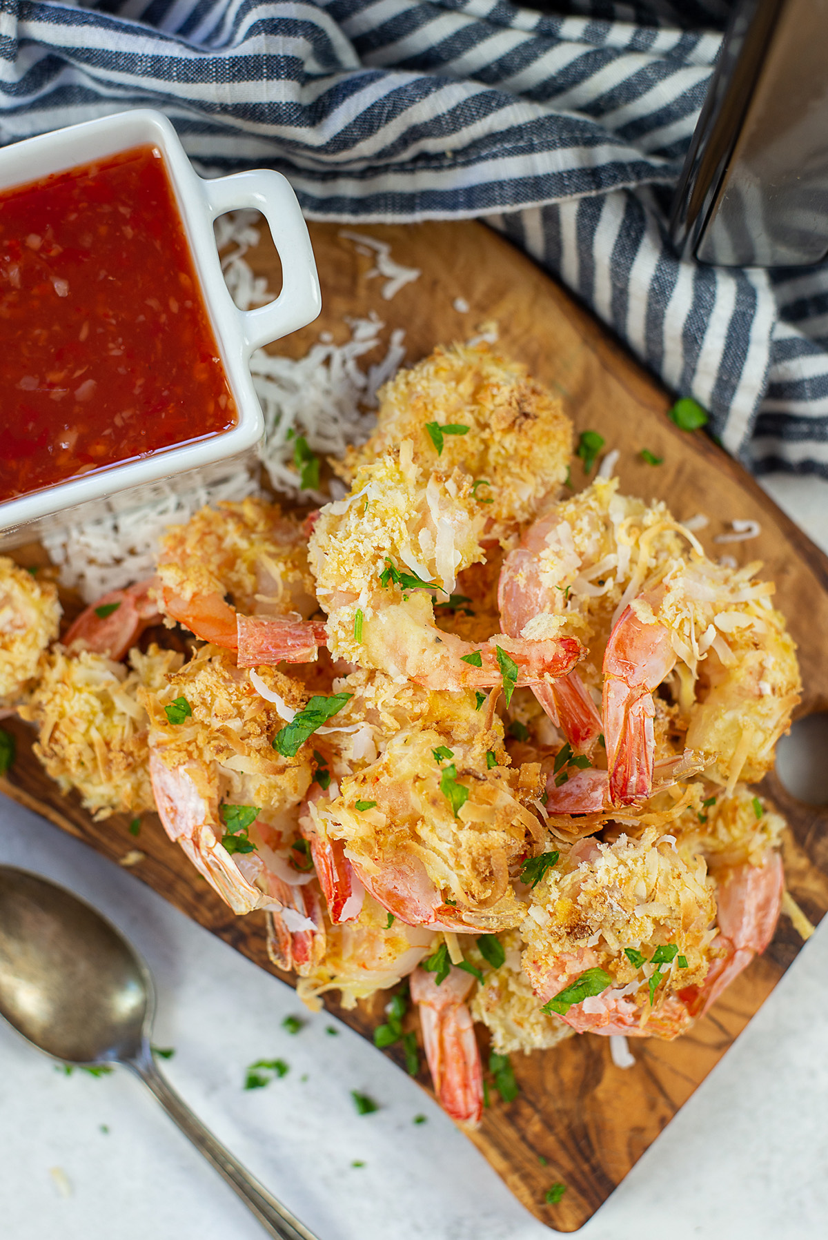 Close up of coconut shrimp on a cutting board.
