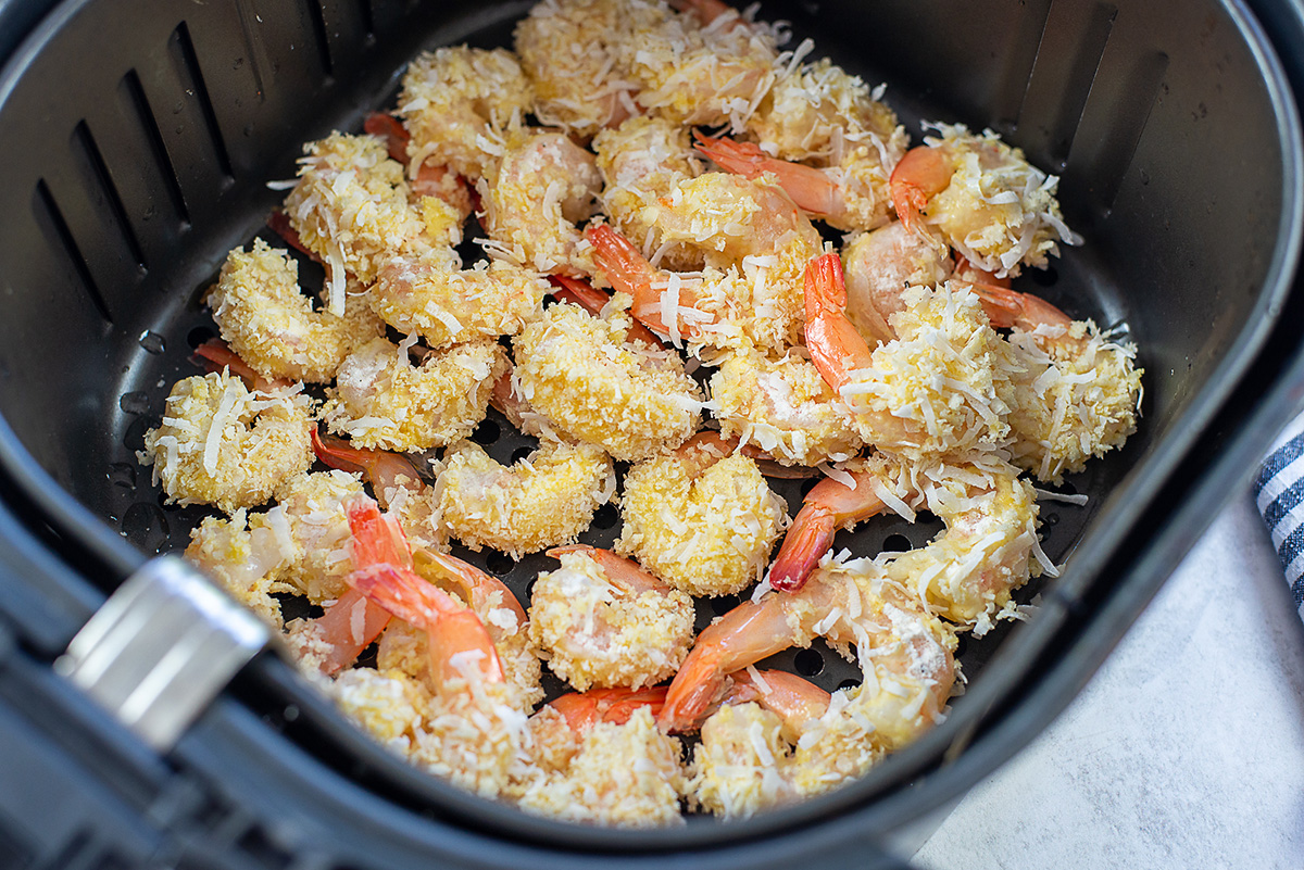 Raw shrimp inside an air fryer basket.