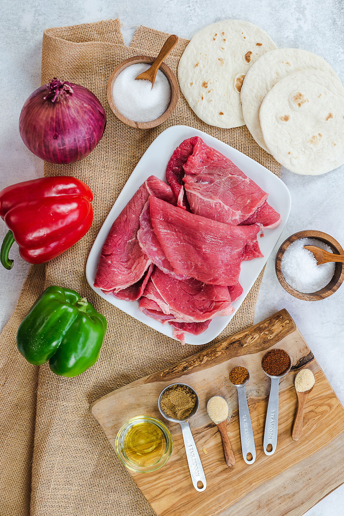 Ingredients for a steak fajita spread on a countertop.