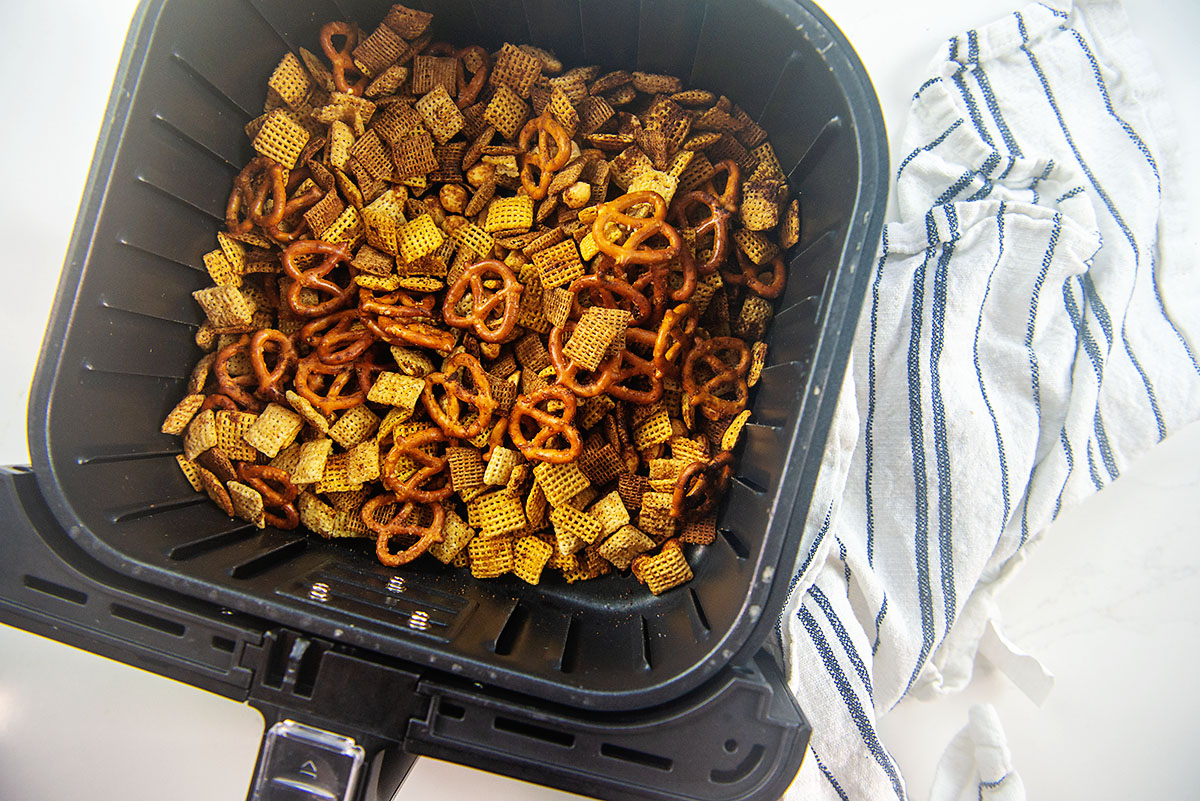Overhead view of Chex mix in an air fryer basket.