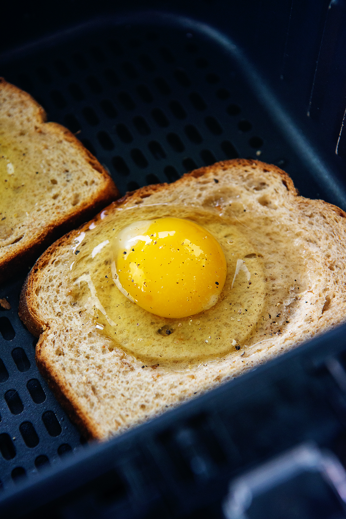 egg cracked onto slice of bread.