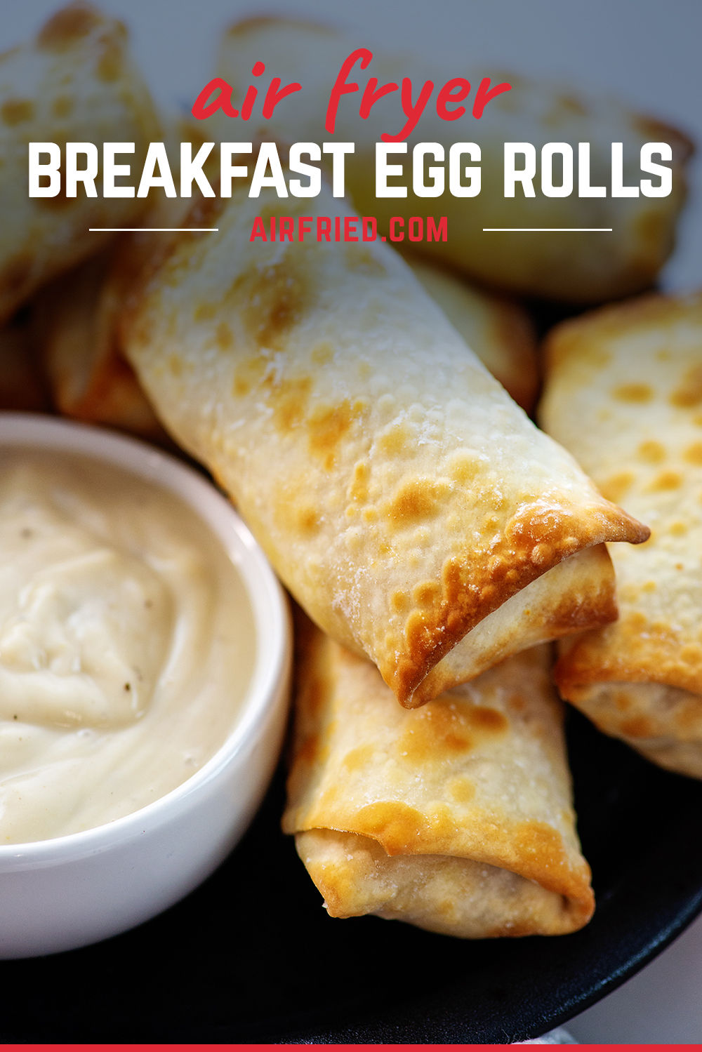 Stack of breakfast egg rolls on a small black plate.