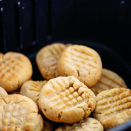 Air fryer basket full of cooked peanut butter cookies.