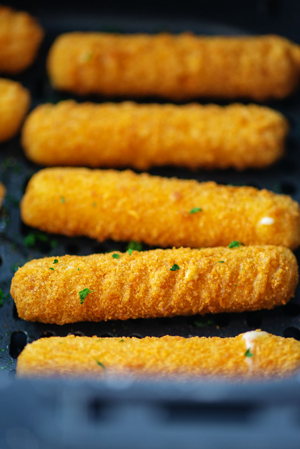 Cooked cheese sticks in an air fryer.