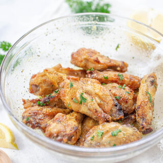 Cooked wings tossed in a clear glass bowl.