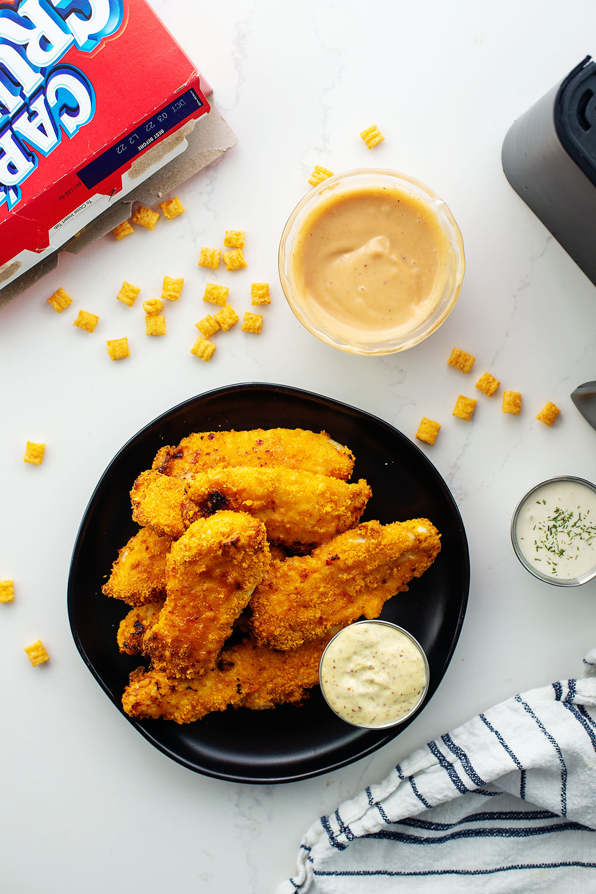 Overhead view of captain crunch cereal next to some chicken strips.