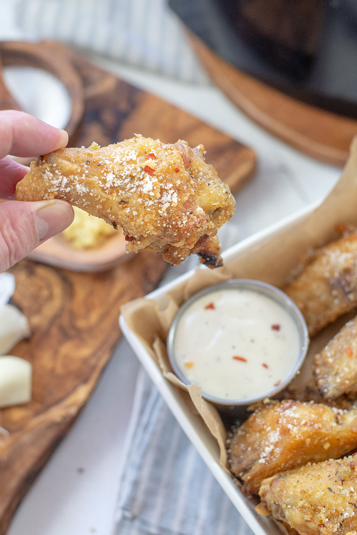 person holding a garlic parmesan wing.