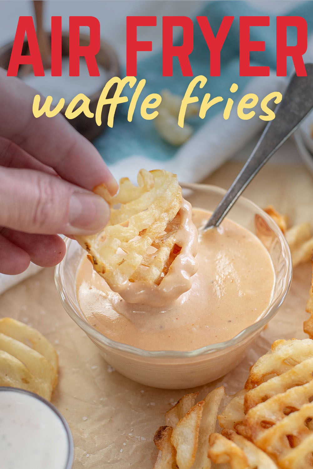 Person dipping a waffle fry in fry sauce.