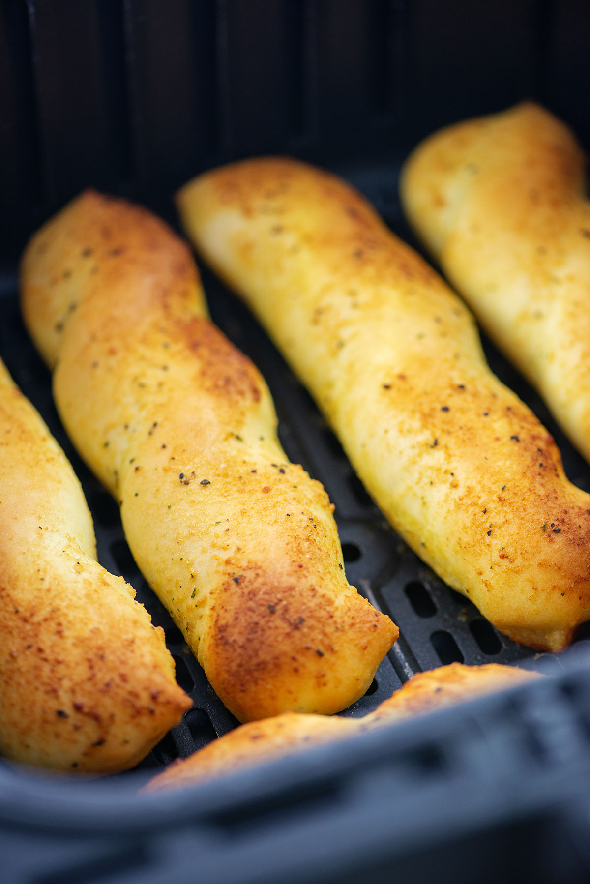 Close up of breadsticks in an air fryer.