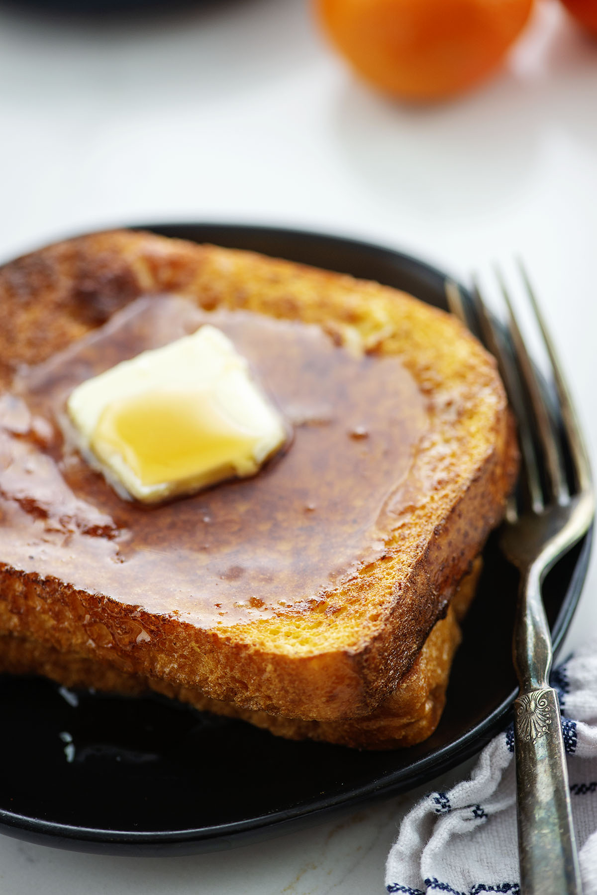 Close up of French toast with butter and syrup on it.
