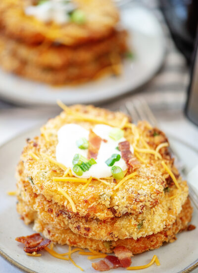 Close up of potato pancakes with a scoop of sour cream on it.