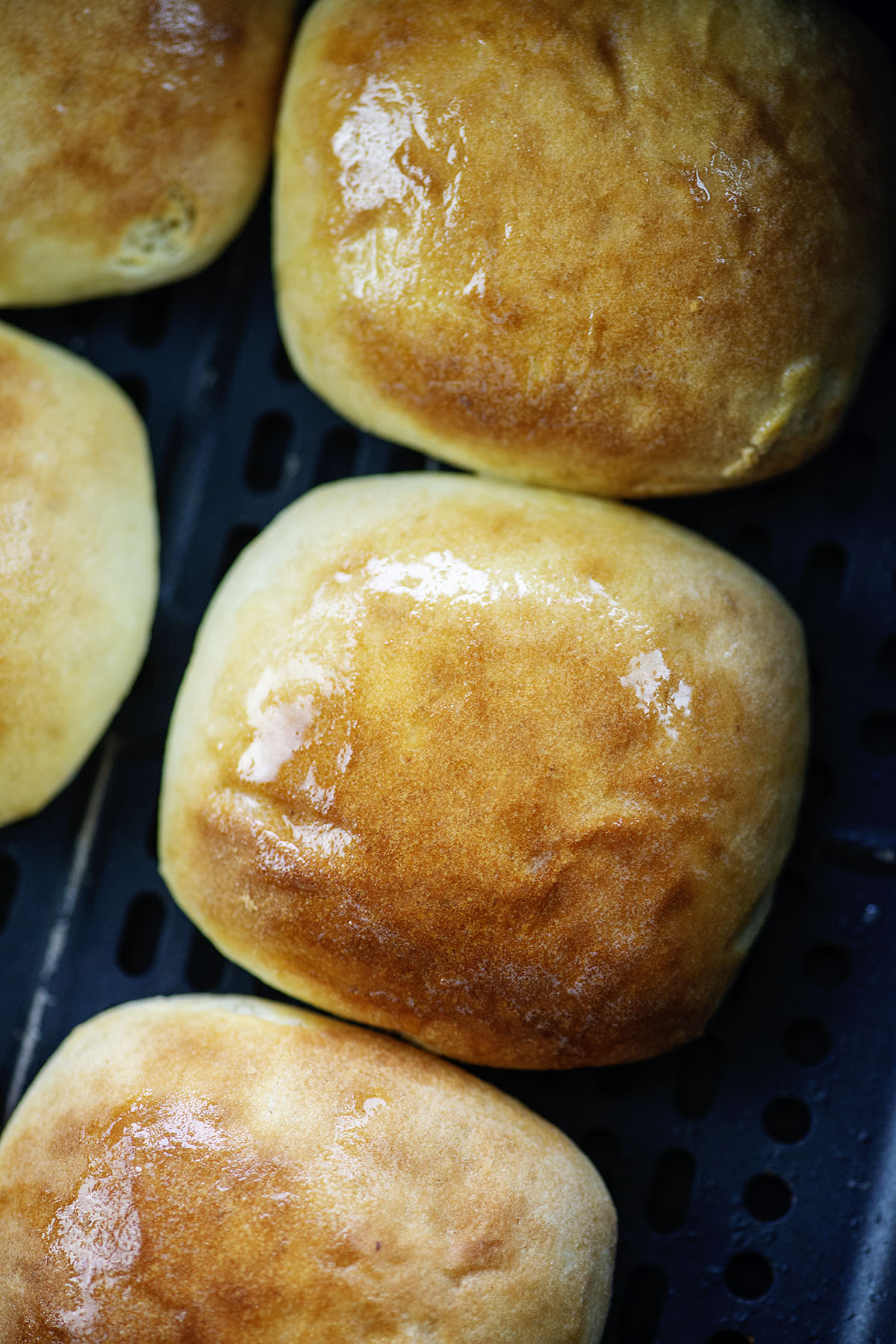 Close up of a dinner roll in an air fryer.