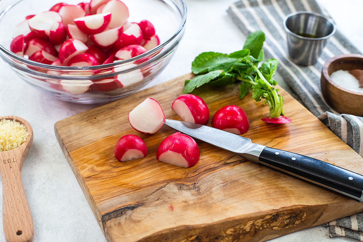 halved radishes on cutting board.