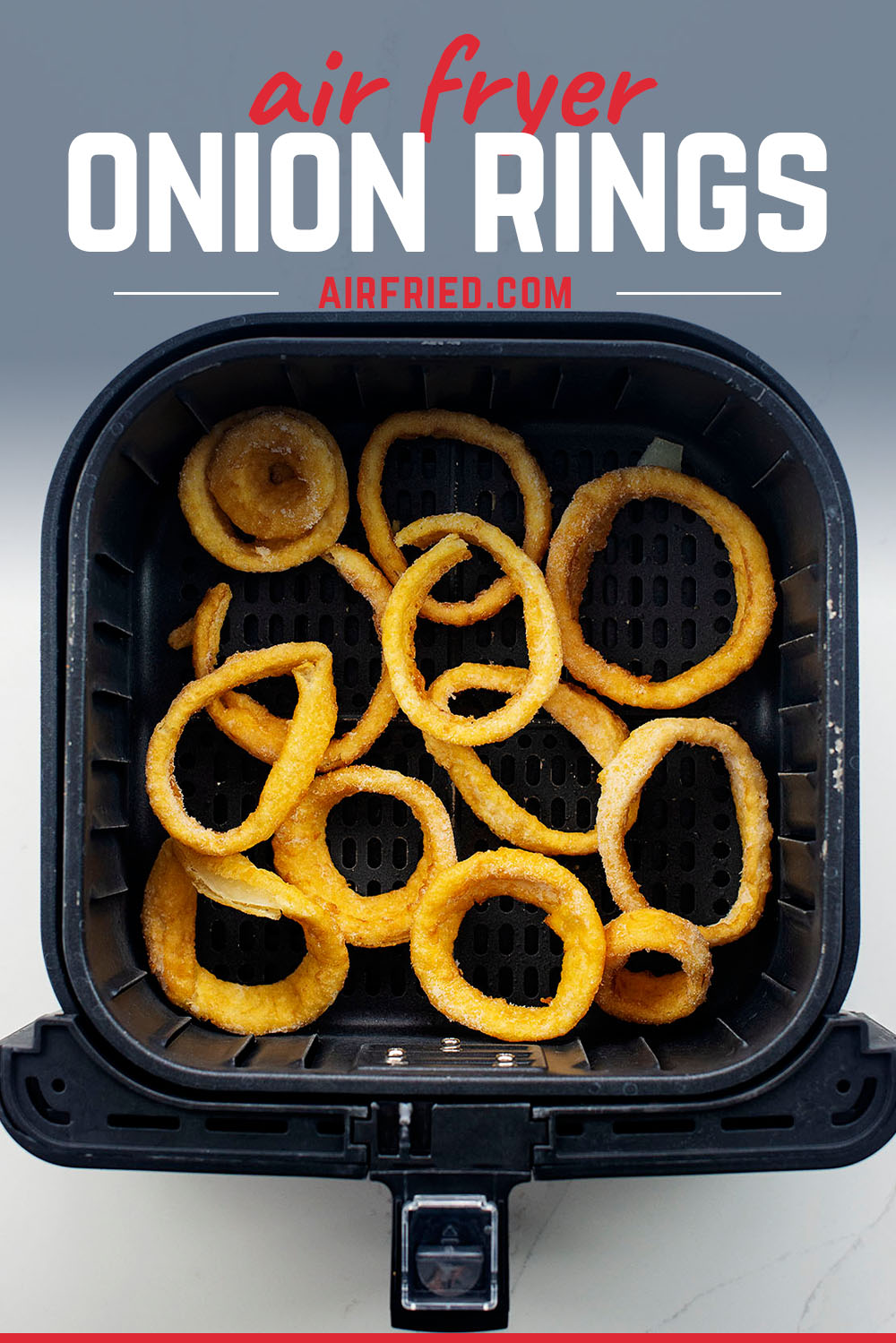 Overhead view of onion rings in an air fryer basket.