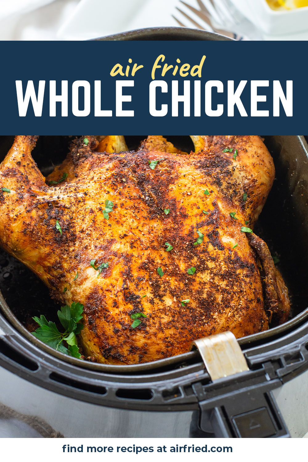 An air fryer basket with a cooked chicken inside.
