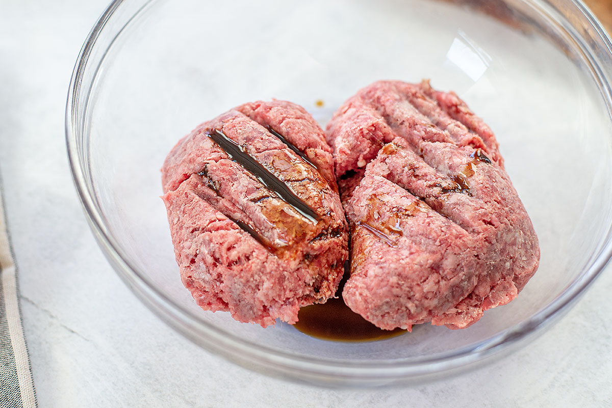 Ground beef in a clear glass bowl.
