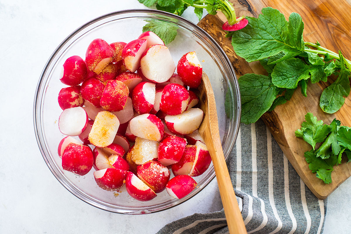 radishes in glass bowl with seasoning.