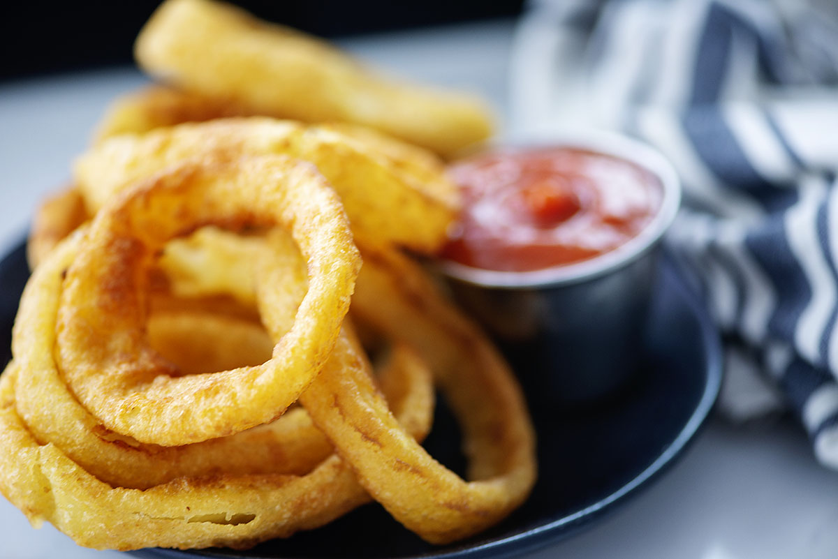 Close up of onion rings on a small black plate