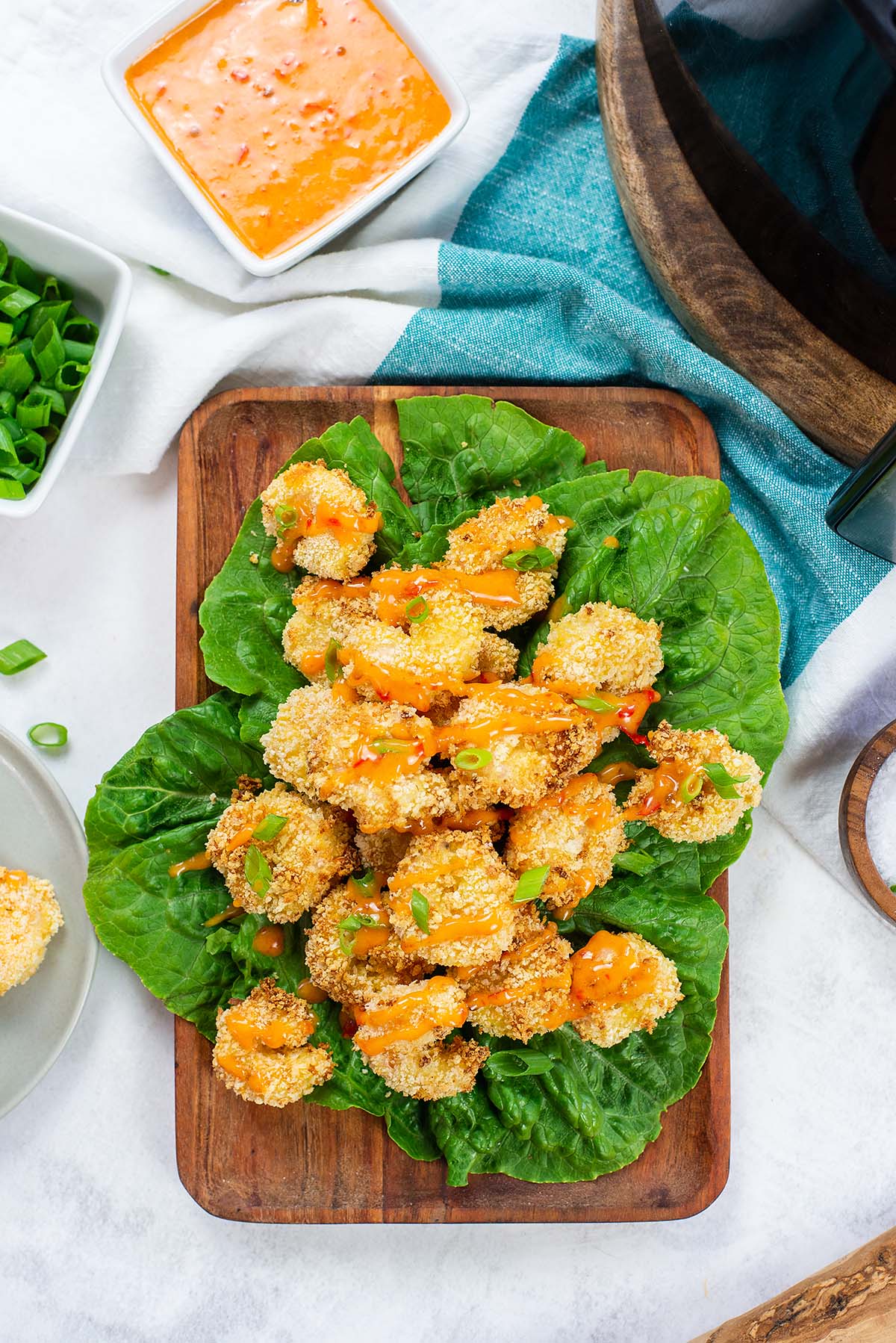 Overhead view of shrimp with bang bang sauce on a lettuce leaf.