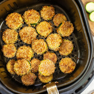 Cooked air fried zucchini in an air fryer basket.