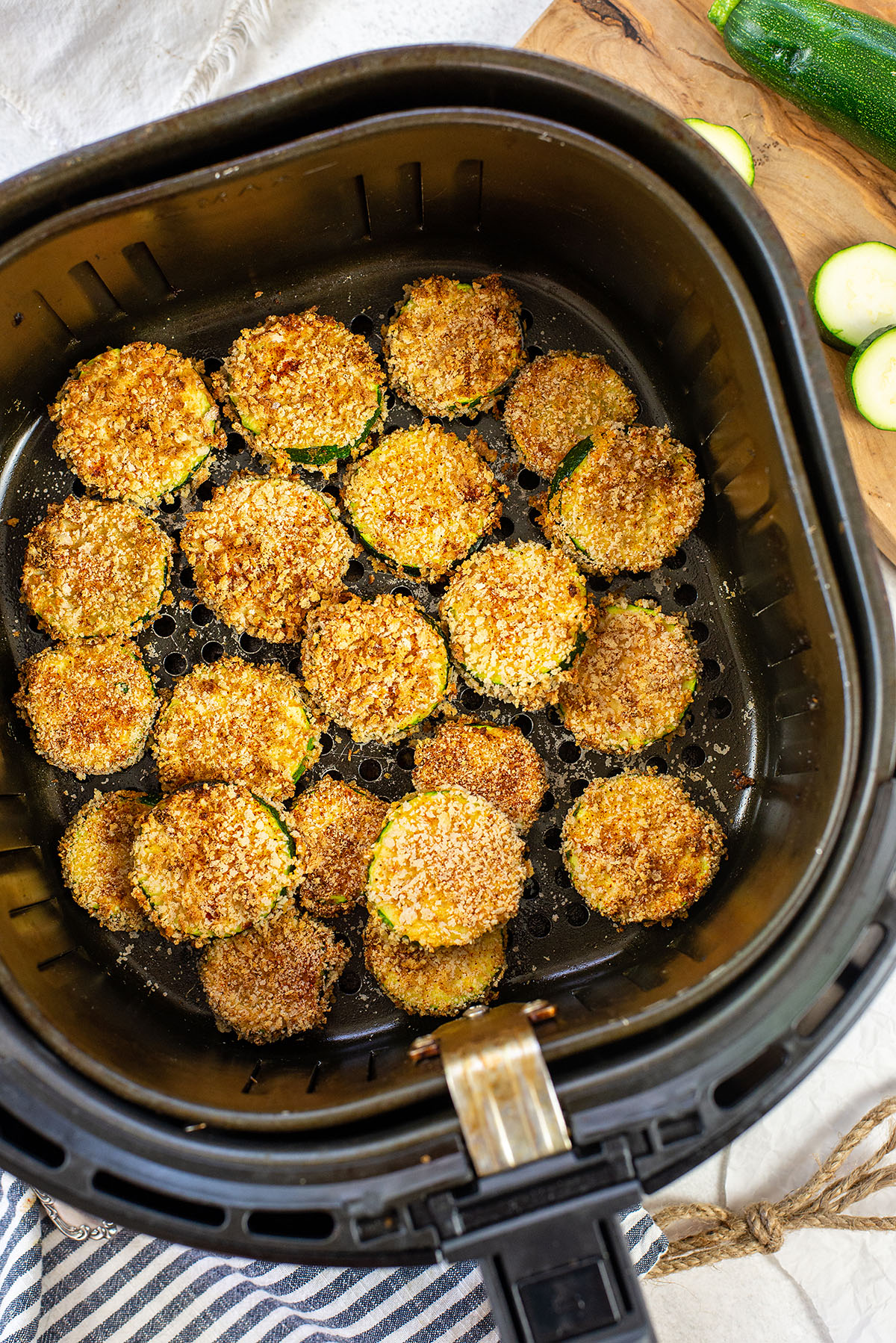 Cooked air fried zucchini in an air fryer basket.