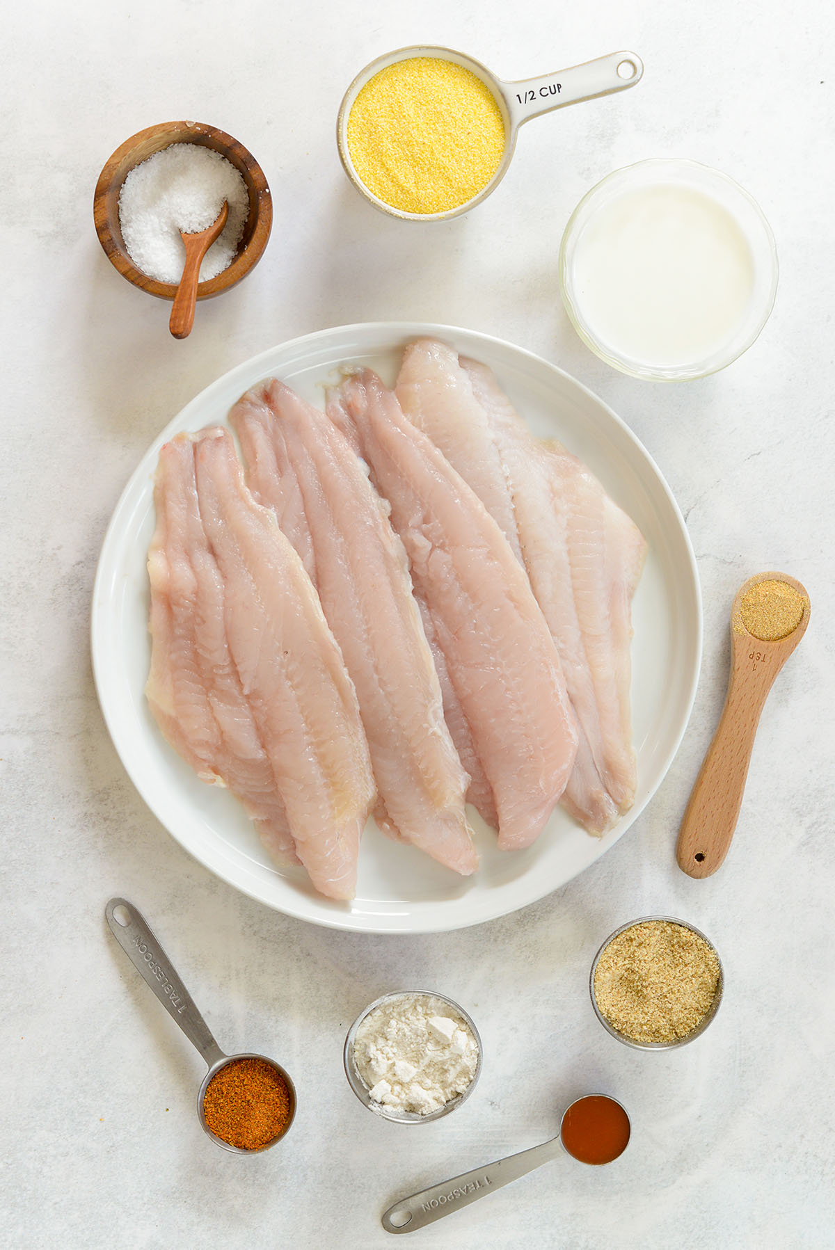 Air fryer catfish fillet ingredients spread out on a countertop.