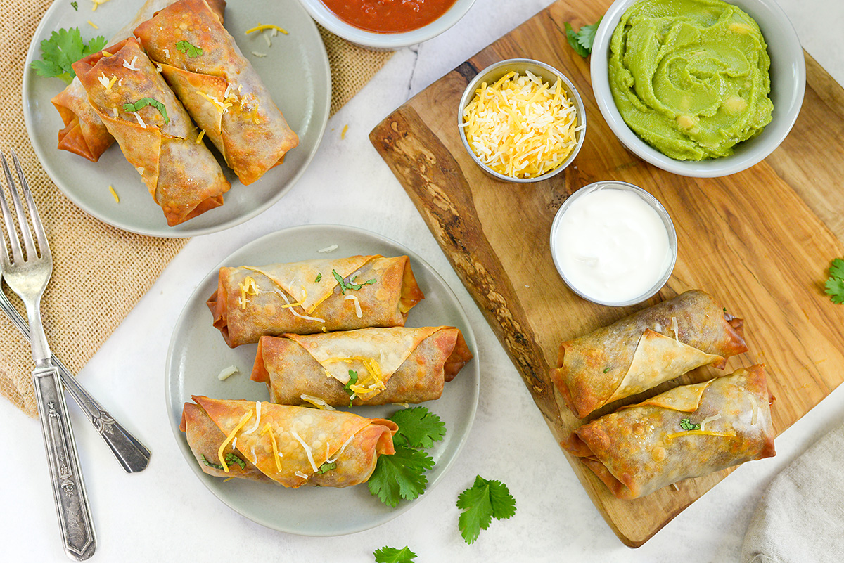 Taco egg rolls spread out on a countertop.