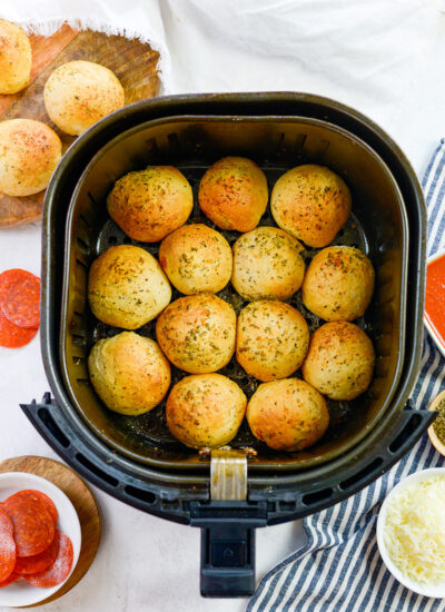 13 pizza bombs in an air fryer basket.