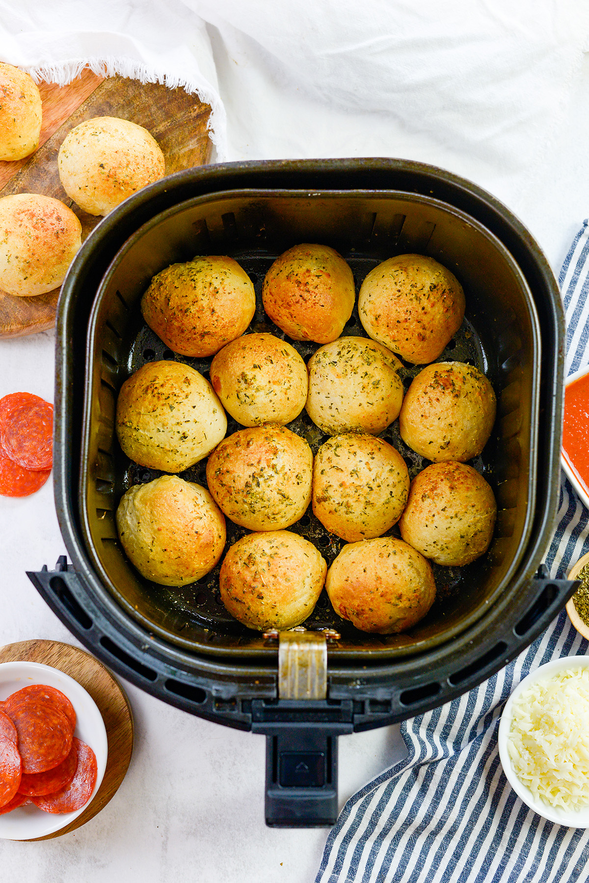 13 pizza bombs in an air fryer basket.