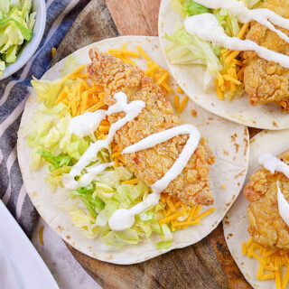 Close up of three chicken snack wraps on a cutting board.