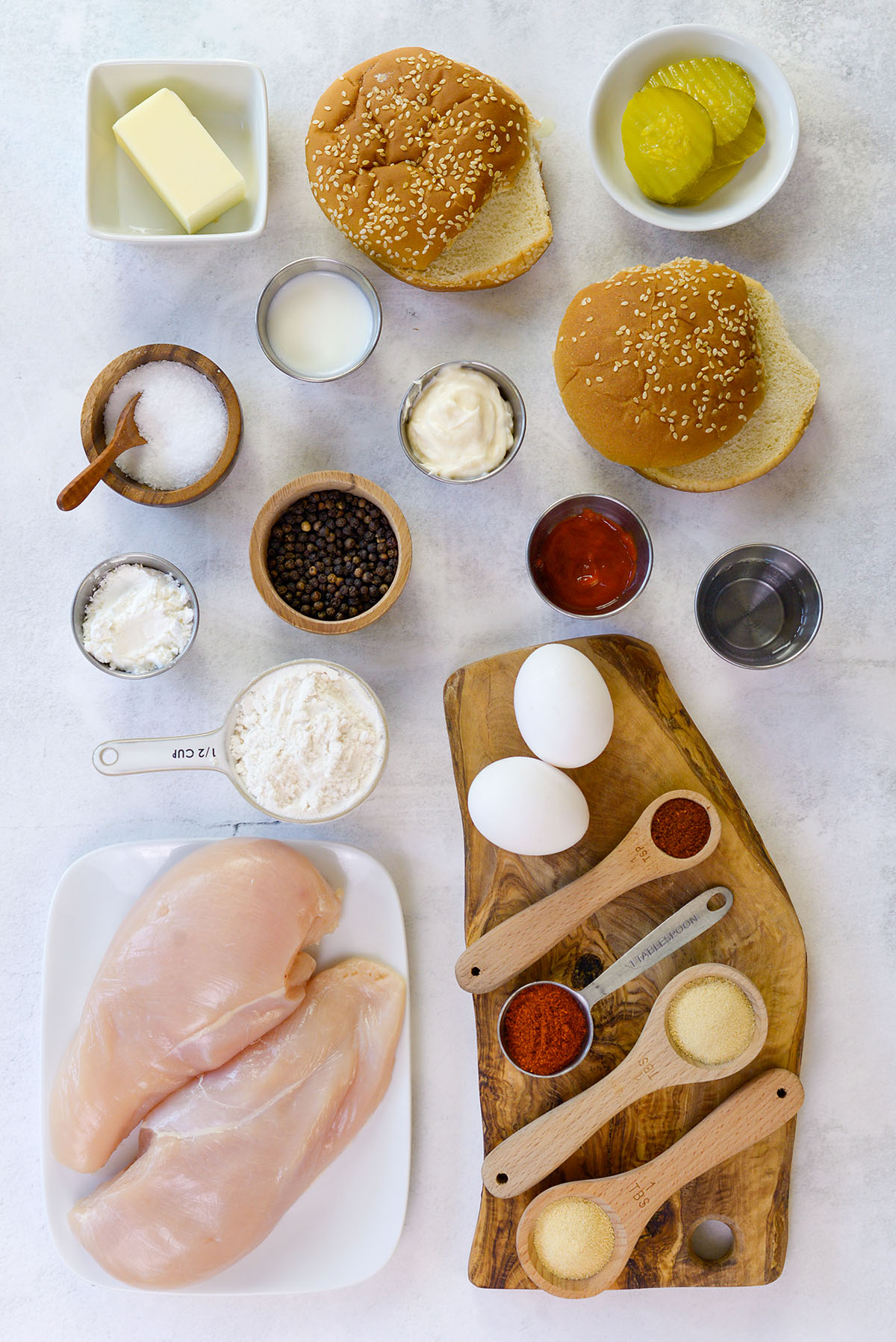 Ingredients for a chicken sandwich all spread out on a countertop.