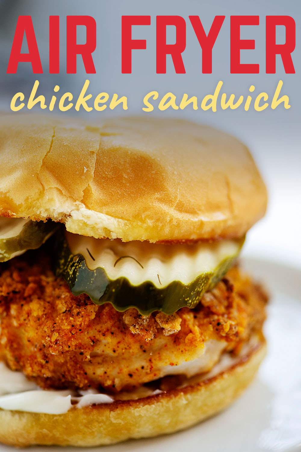 Close up of a chicken sandwich with pickles on it.
