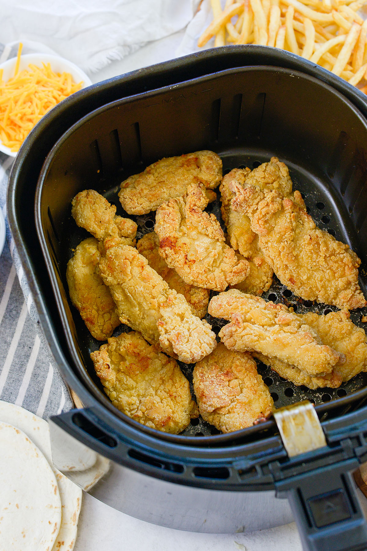 chicken strips in air fryer basket.