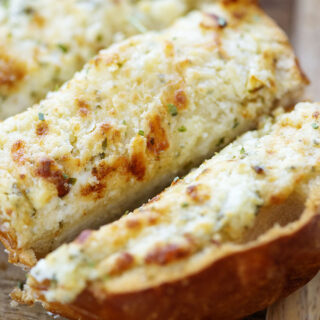 Close up of a piece of garlic cheese bread.