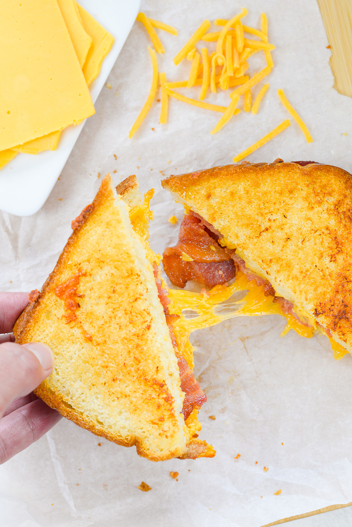 Close up of a bacon grilled cheese being pulled apart.