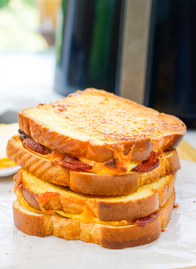 Two cooked grilled cheese sandwiches stacked on top of each other.