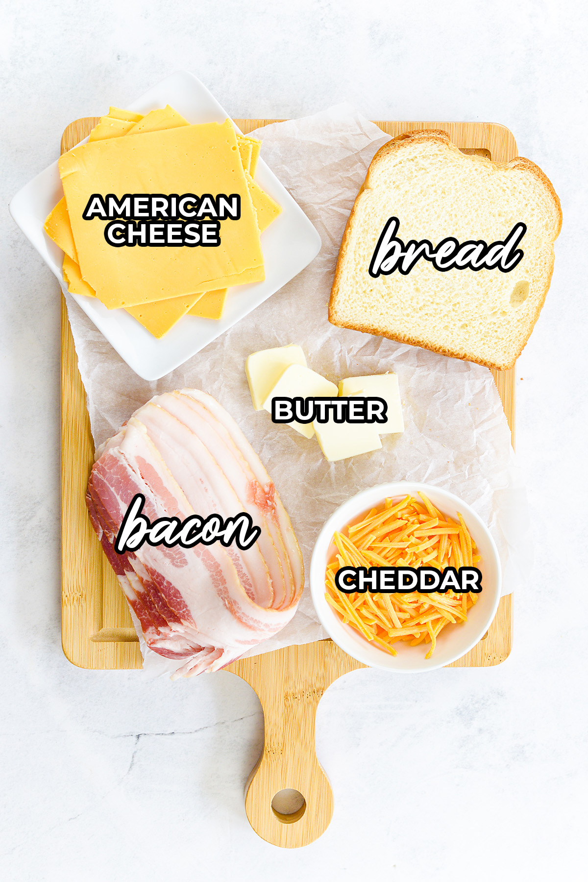 Bacon grilled cheese ingredients on a wooden cutting board.