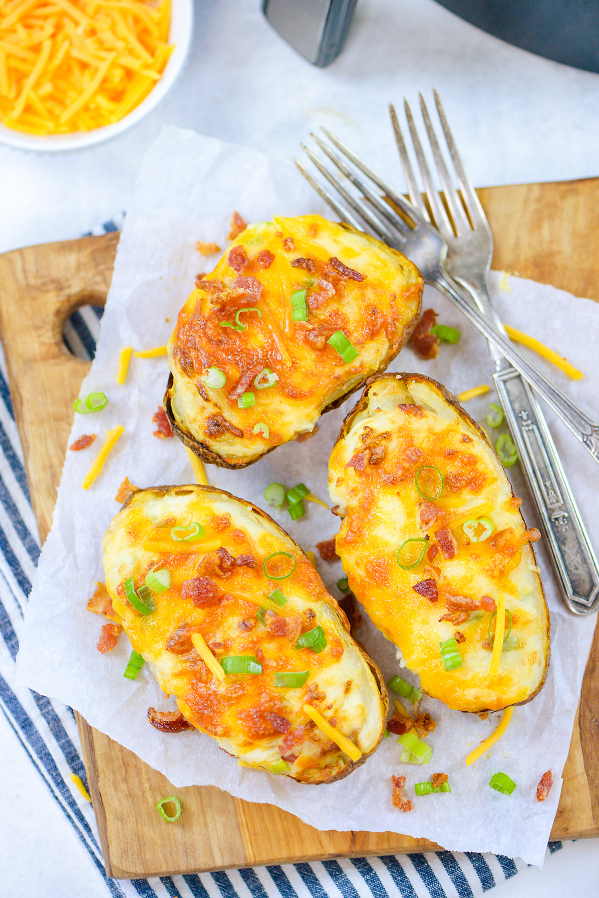 Three twice baked potatoes with two forks.