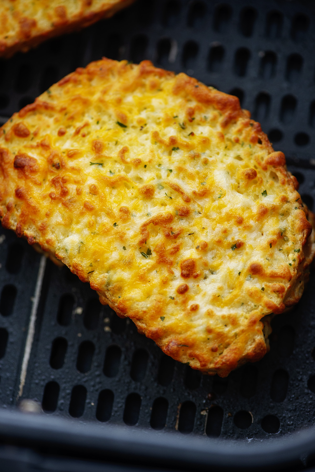 Close up of a slice of garlic bread that was cooked in an air fryer.